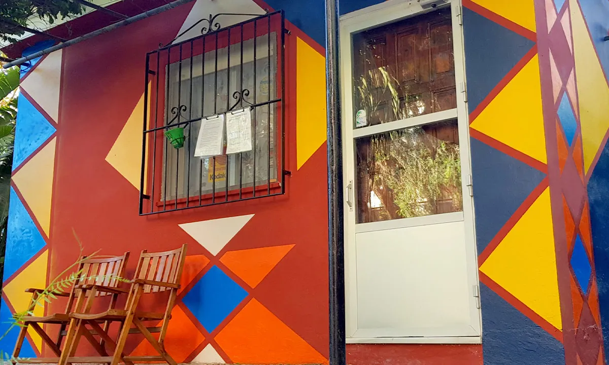 Mural geométrico pintado a mano en colores terracota, mostaza y azul